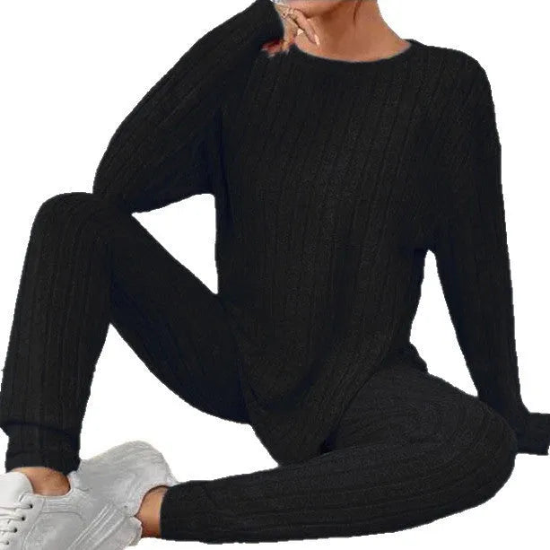 Black sunken stripe two-piece loungewear set with top and trousers on a hanger.