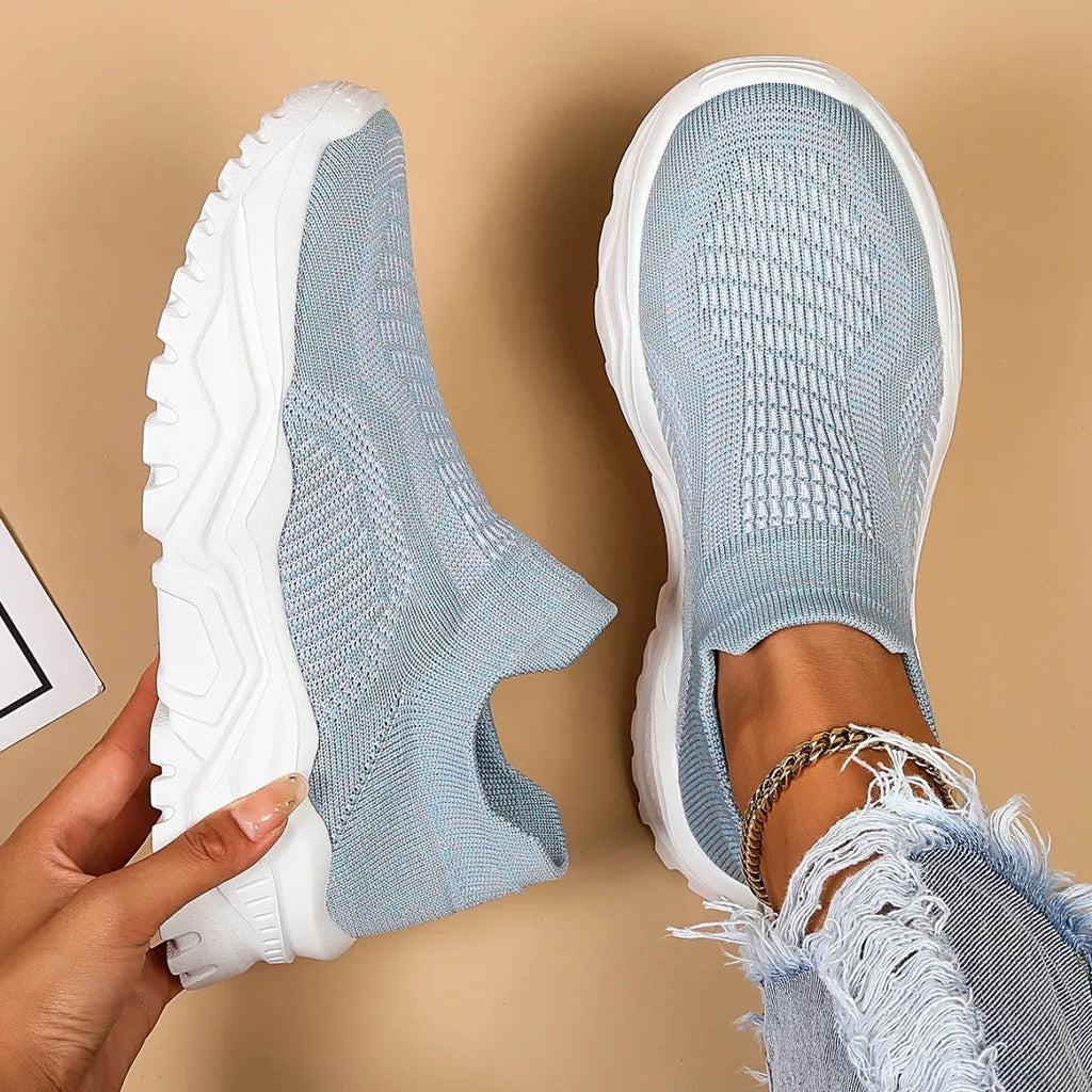 Women's light blue mesh slip-on sports shoes with a rounded toe and mid heel.