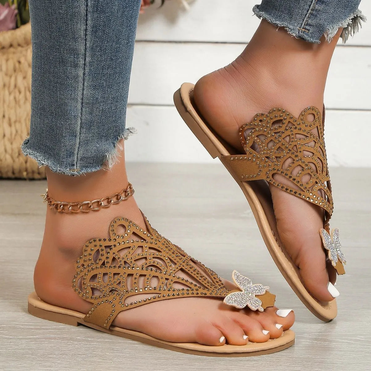 Women's black slip-on sandals with rhinestone details, a flip-toe strap, and a flat rubber sole.
