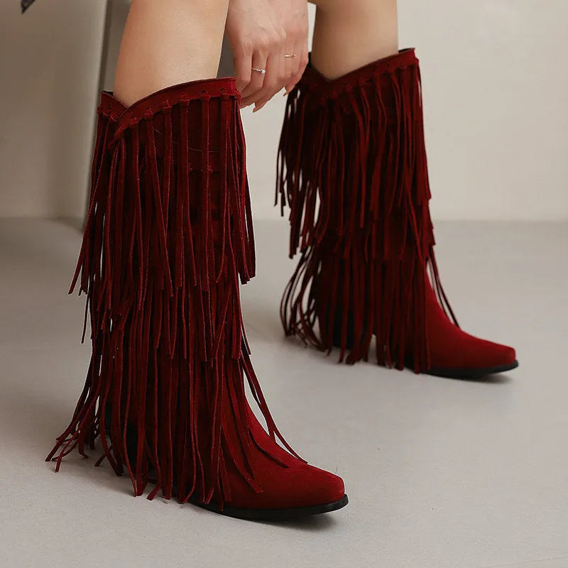 Women's brown suede knee-high boots with a chunky heel, platform sole, and tassel detail on the front.