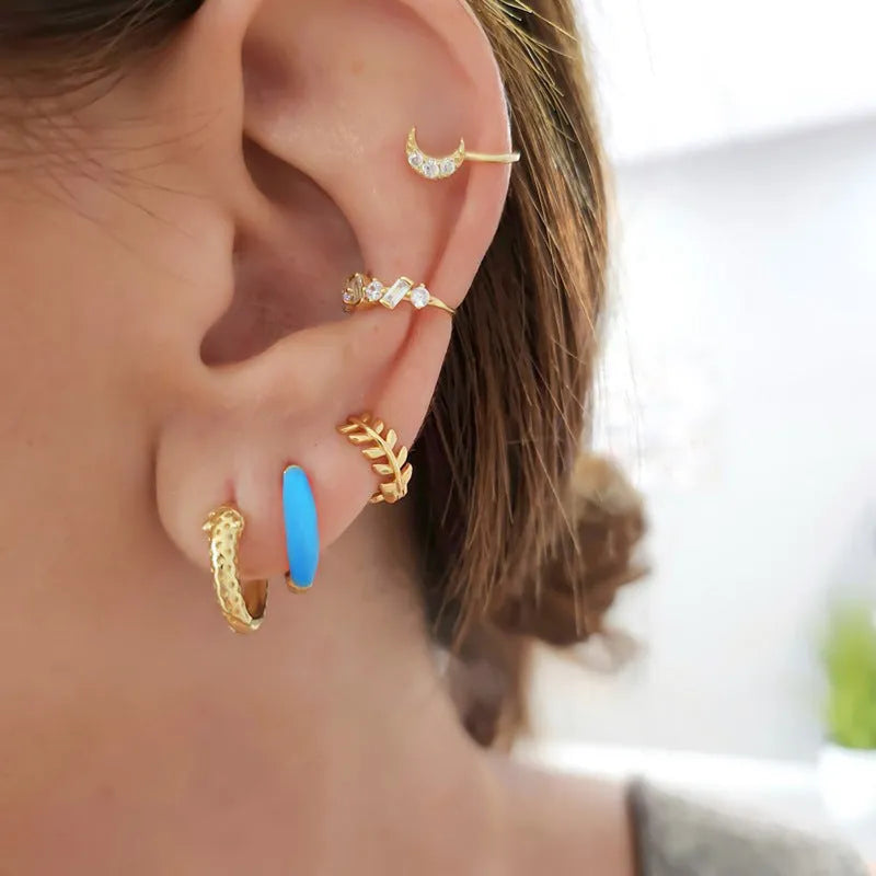 A pair of oval-shaped, U-curved epoxy earrings in a solid colour on a plain background.