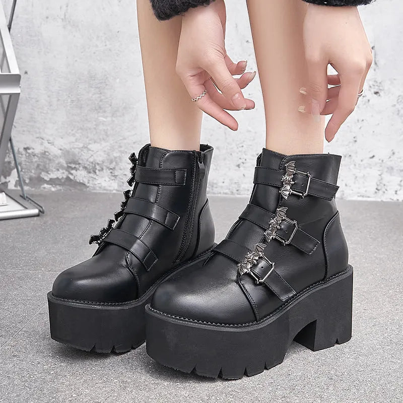 Black women's ankle boots with bat buckle, side zip, and thick heel.