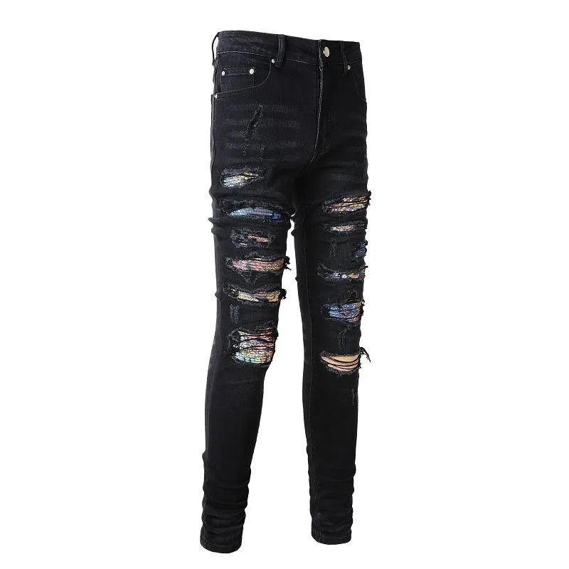 Men's black tattered stretch denim jeans with printed patch on a white background, front view