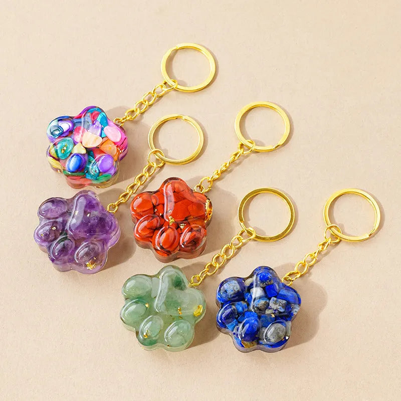 Natural crystal cat's paw keychain pendant in pink crystal, showing detailed 3D carving and metal keyring.