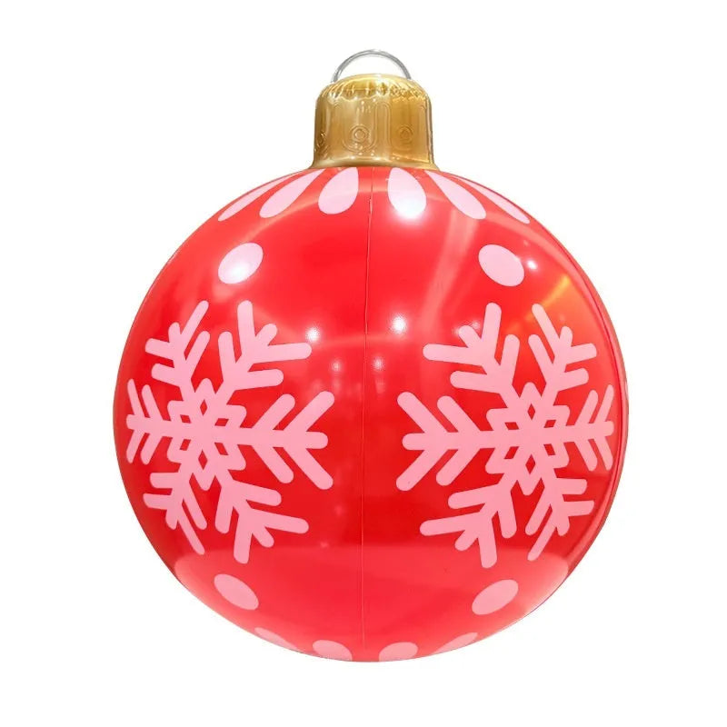 Large red inflatable Christmas ball with flashing LED lights standing in a garden.