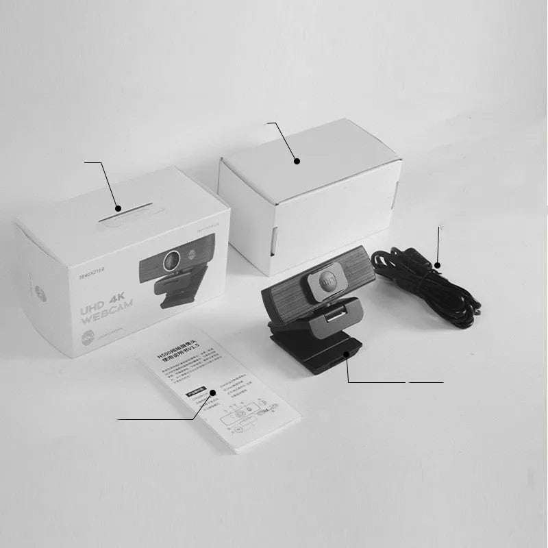 Black 4K USB webcam with attached cable and a magnetic privacy cover on a desk.