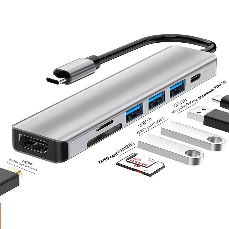 Silver USB Type-C 7-in-1 expansion dock with HDMI port and 15cm attached cable on a desk.