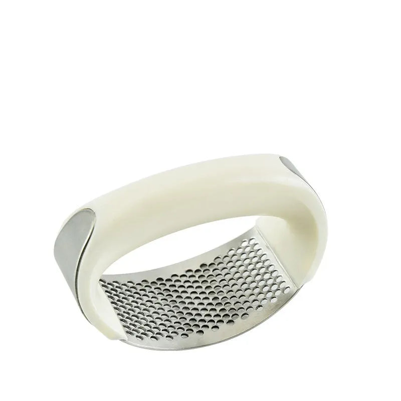 Stainless steel garlic press with ergonomic handle in assorted colours on a kitchen counter.