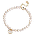 Women's freshwater pearl bracelet with a fan-shaped shell clasp on a wrist.