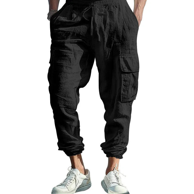 Man wearing loose-fit khaki linen casual trousers with ankle ties and multiple pockets.