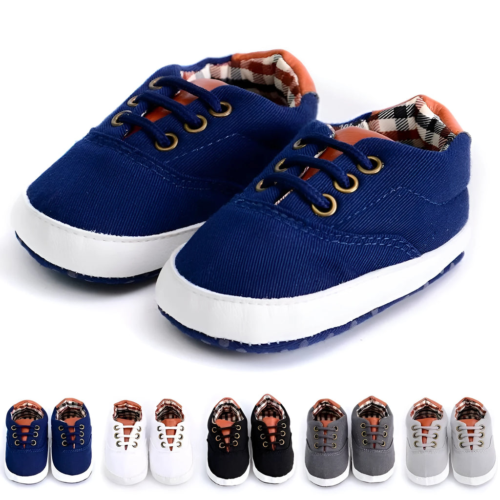 Solid colour baby canvas shoes with a front strap, shown in light grey on a white background.