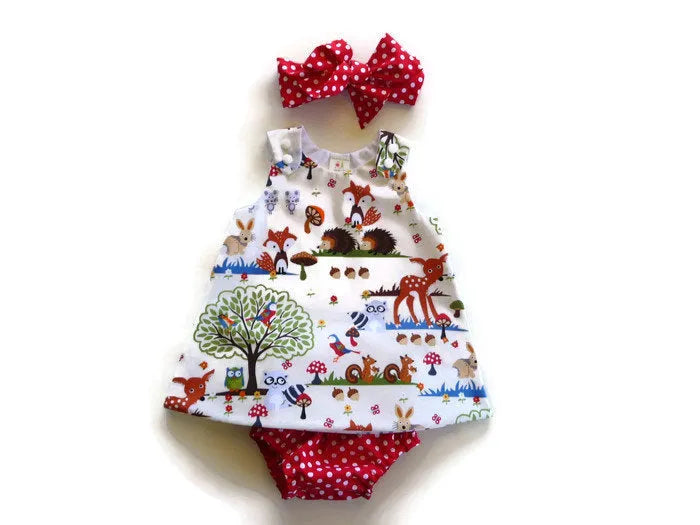 Red cartoon print cotton three-piece suit set for a baby girl, featuring a dress, shorts, and headband.