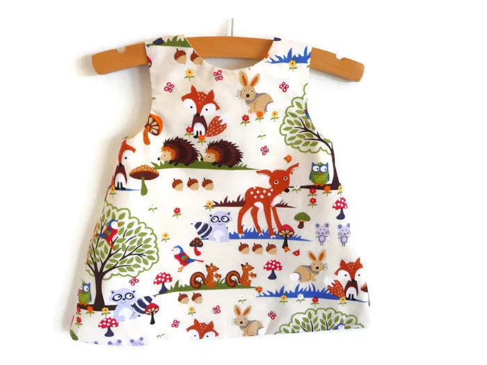Red cartoon print cotton three-piece suit set for a baby girl, featuring a dress, shorts, and headband.