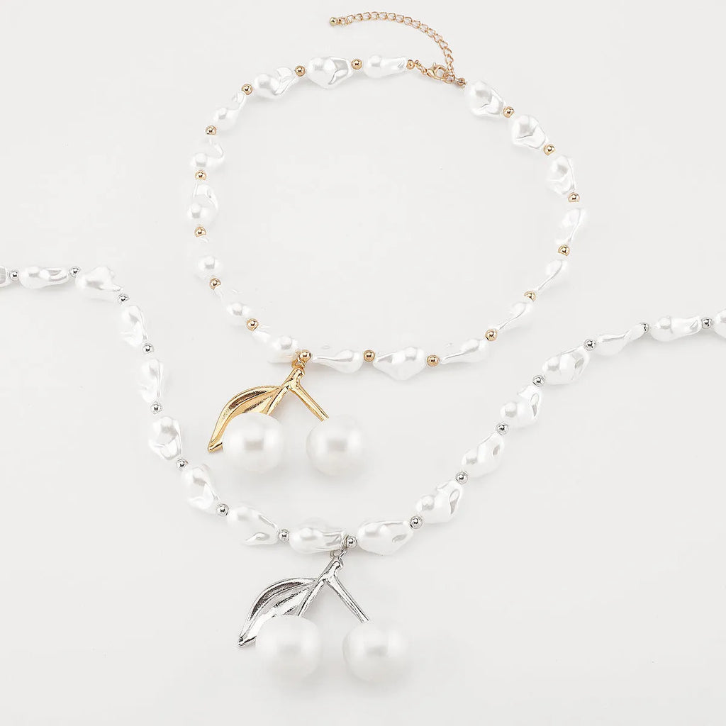 Gold irregular cherry fruit pendant on an adjustable imitation pearl chain necklace for women.