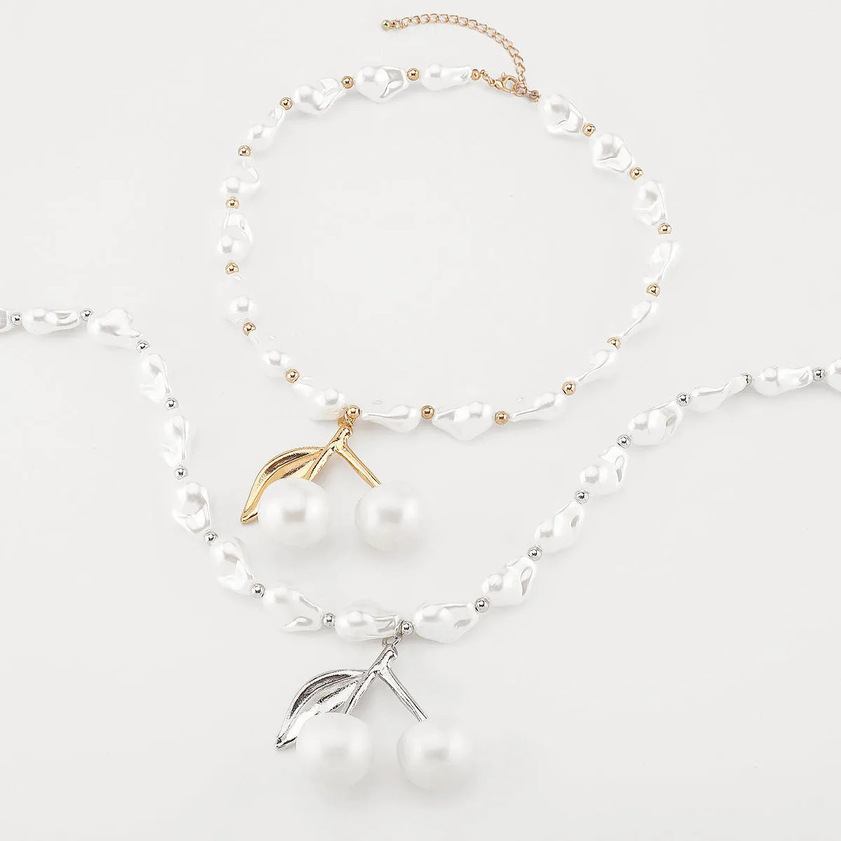 Gold irregular cherry fruit pendant on an adjustable imitation pearl chain necklace for women.