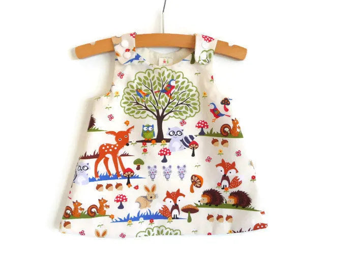 Red cartoon print cotton three-piece suit set for a baby girl, featuring a dress, shorts, and headband.