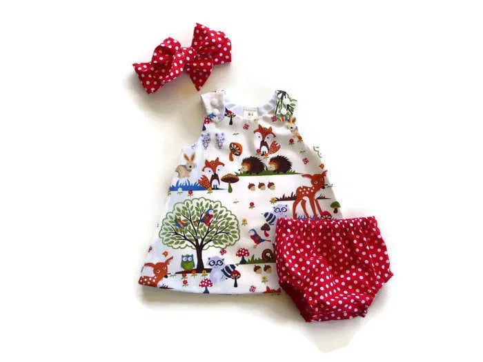 Red cartoon print cotton three-piece suit set for a baby girl, featuring a dress, shorts, and headband.