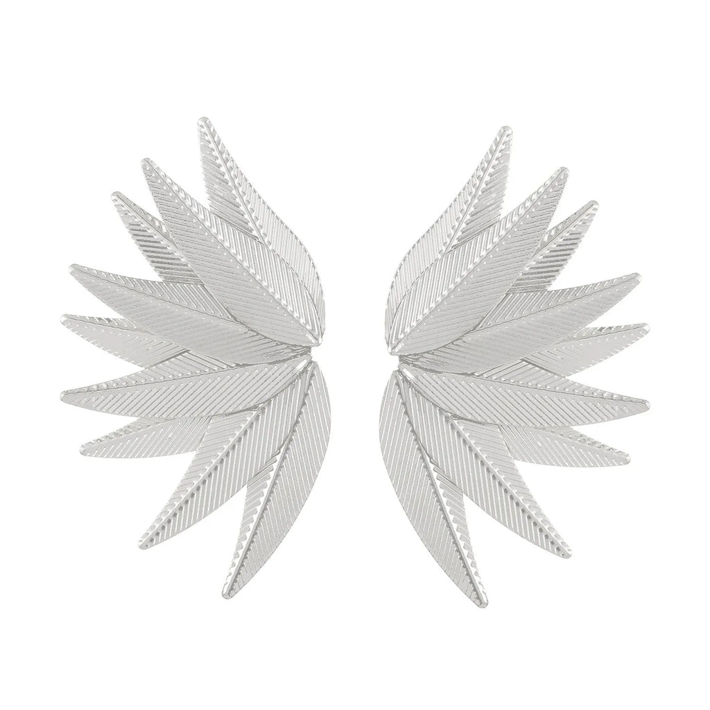Gold and white alloy leaf shape patch earrings on a flat surface