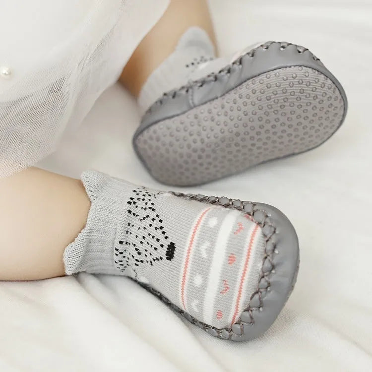 Pair of pastel coloured baby socks with anti-slip dots on the sole, shown flat.