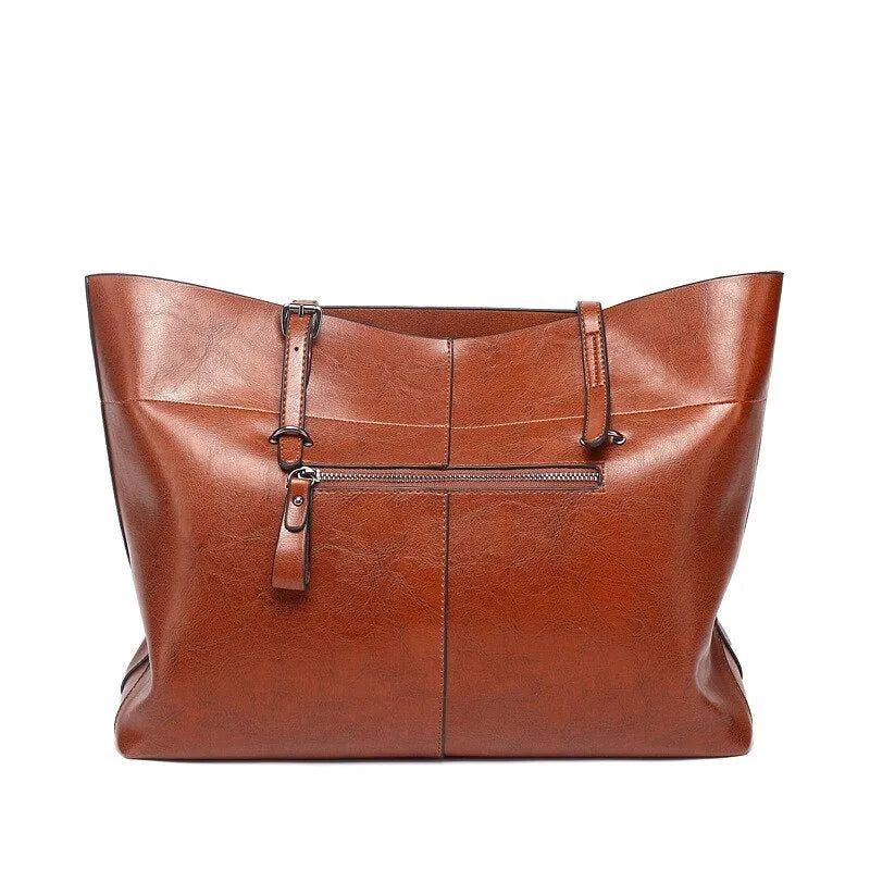 Brown waxed cowhide cross-body handbag with zip, showing two compartments and adjustable strap.