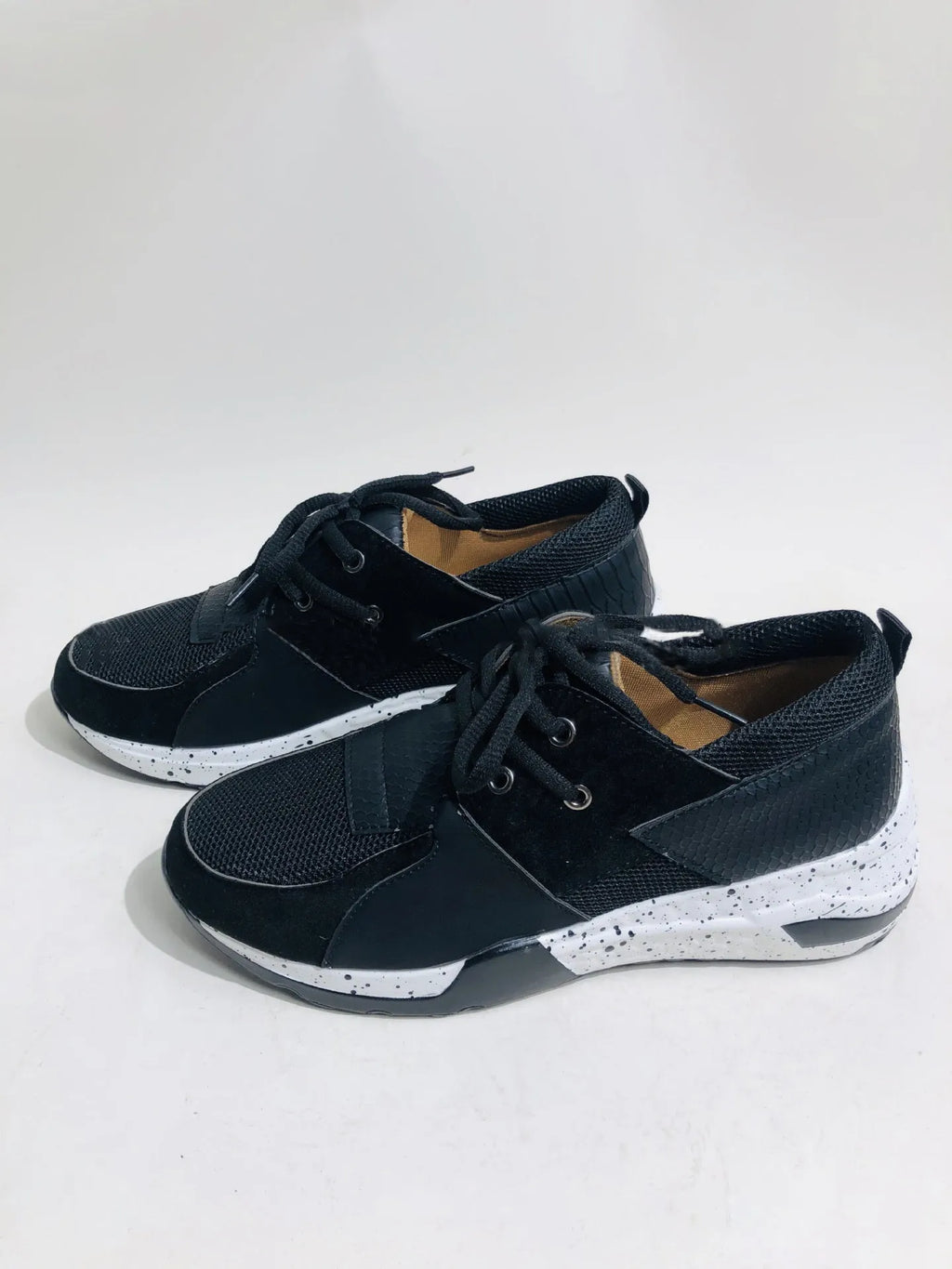 Women's black suede casual sneakers with a low wedge heel and round toe on a white background.