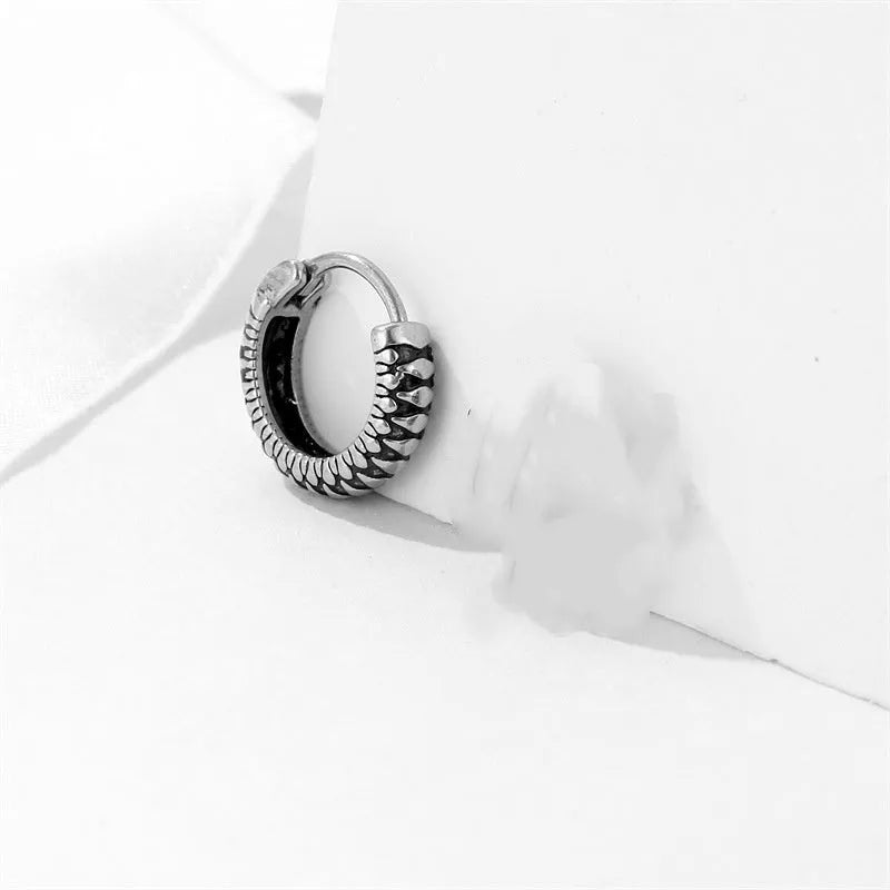 A pair of silver geometric twist earrings made from stainless steel alloy on a white background.