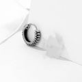 A pair of silver geometric twist earrings made from stainless steel alloy on a white background.