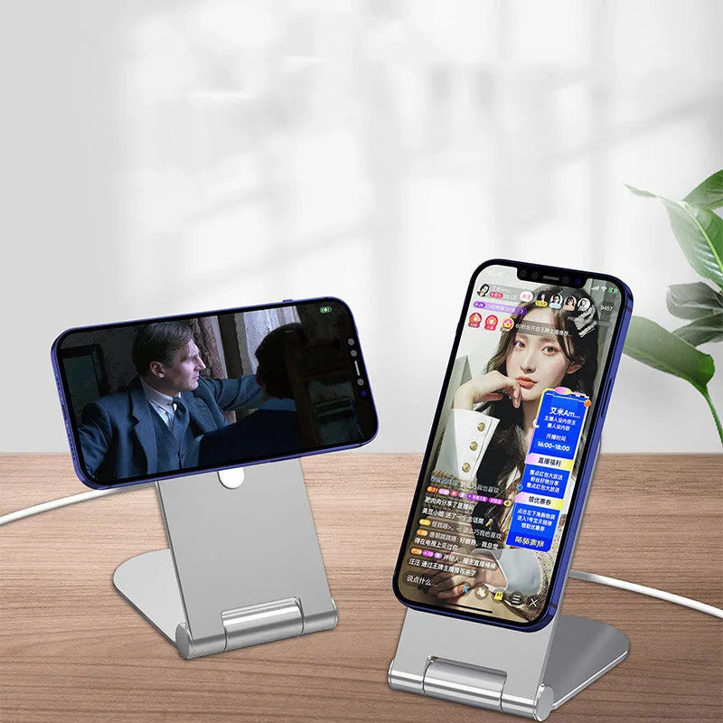Silver aluminium alloy and plastic magnetic phone bracket for iPhone 12 on a desk.