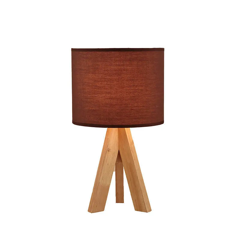 Solid wood LED table lamp with fabric shade in linen trumpet colour on wooden bedside table