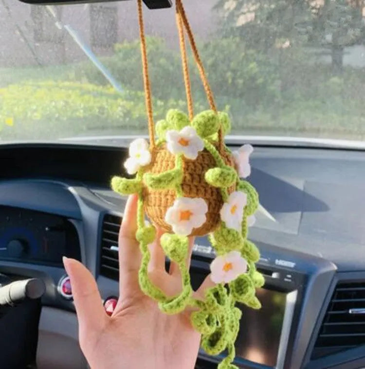Green and white knitted wool car plant ornament hanging from a rope