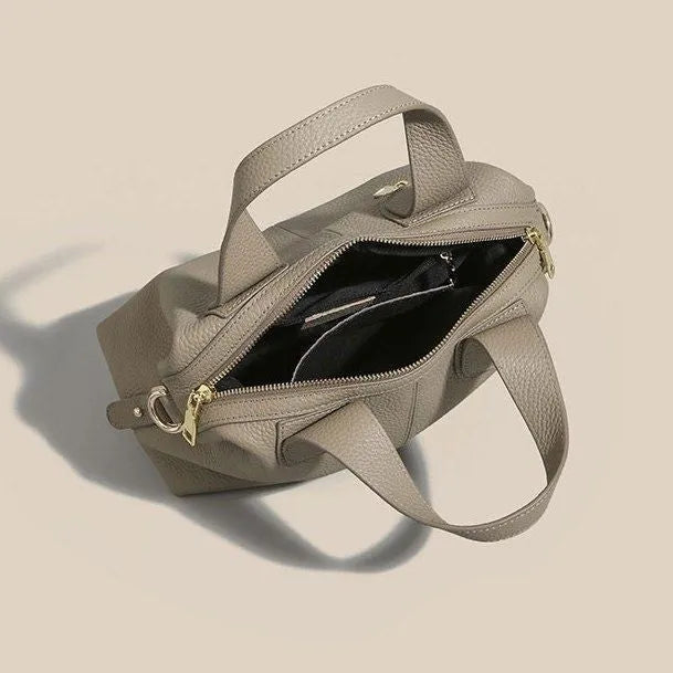 Black genuine leather women's cross-body shoulder bag with square shape and cross-body strap.