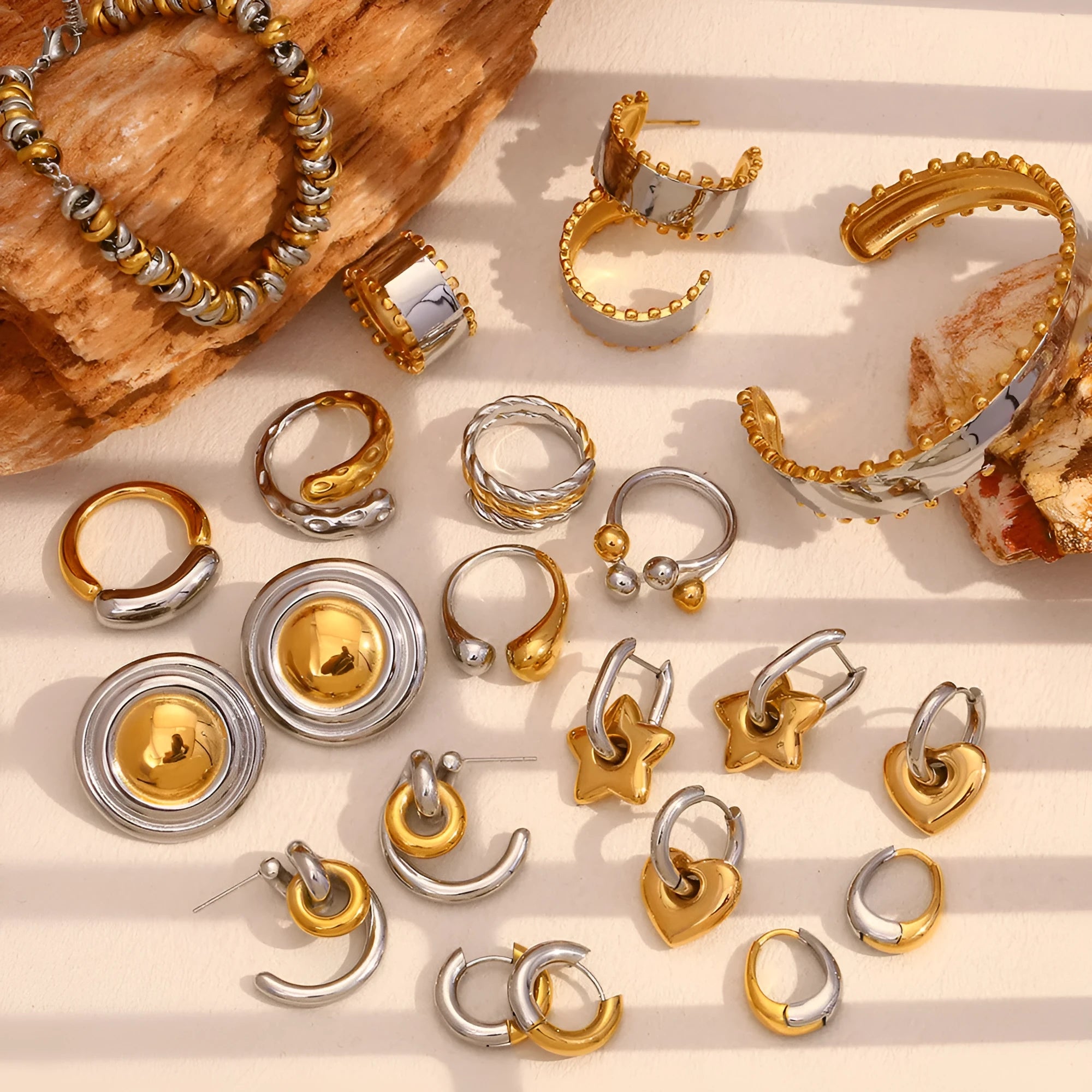 Gold geometric earrings, bracelet, and necklace set on a plain background
