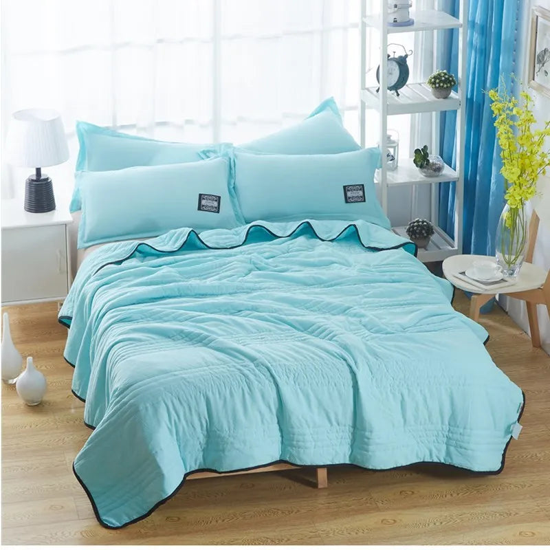 Lightweight seersucker summer quilt in various colours on a bed
