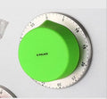 Green and silvery kitchen stainless steel mechanical timer with dial and magnetic back on fridge