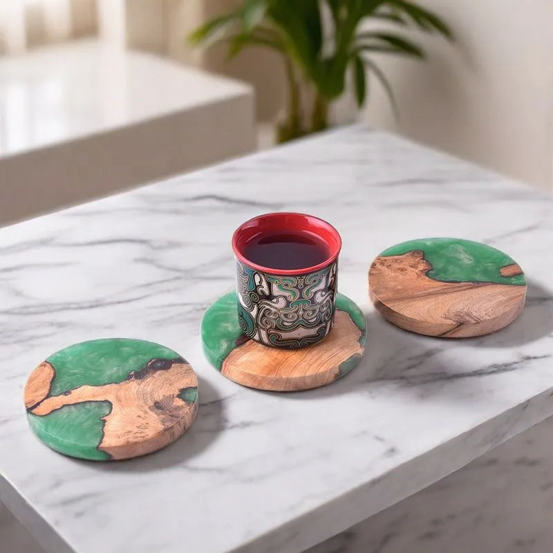 Solid colour resin coaster on a wooden table next to a mug, showing round tumour green and black options.