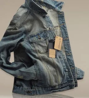 Men's straight fit cotton denim jacket in blue with chest pockets and button front on a hanger