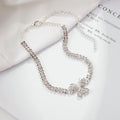 Gold rhinestone butterfly anklet with bow shape and gemstone inlay on white background