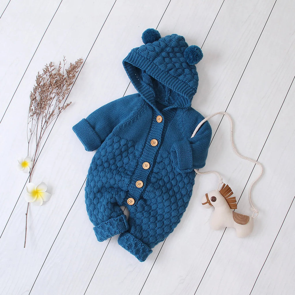 Hooded knitted jumpsuit in 100% acrylic fabric available in multiple colours with long sleeves