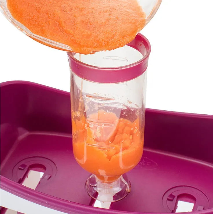 Baby food maker squeeze station pressing homemade fruit puree into 4oz pouch on countertop