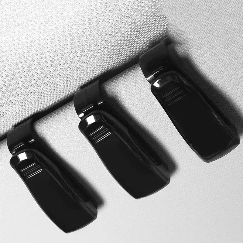 Black plastic car sunshade clip for holding glasses and cards, measuring 6.5 by 2.3 centimetres.