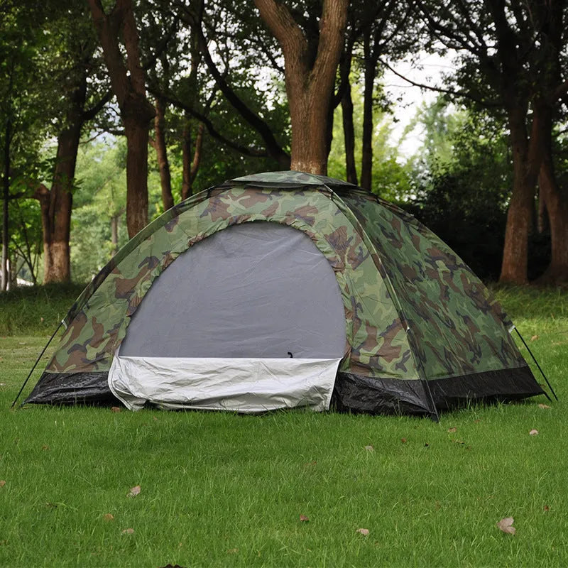 Green camouflage two-person tent with mesh windows and triangular skylight, shown erected outdoors.