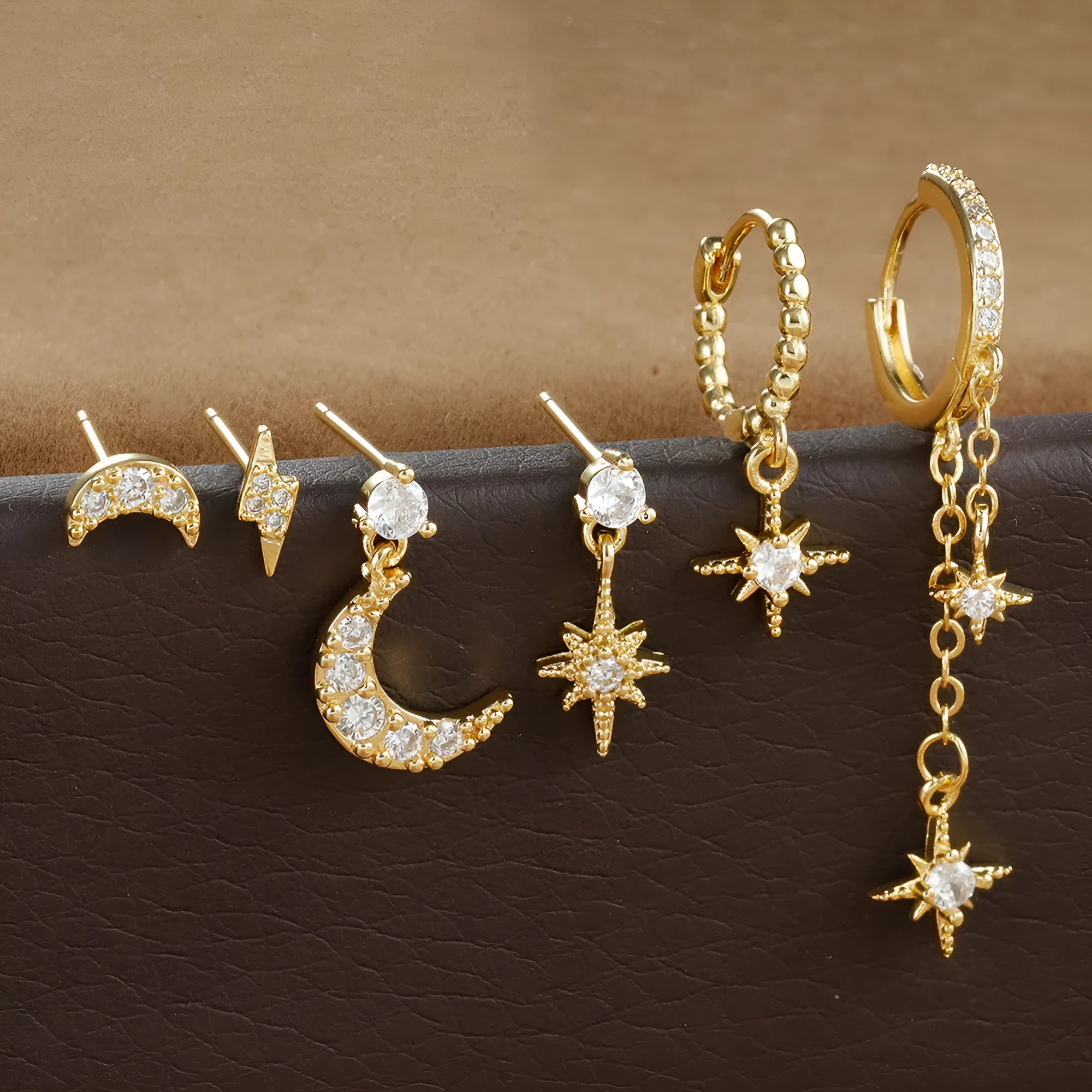 Six gold chain tassel earrings with zircon studs arranged as a complete jewellery set