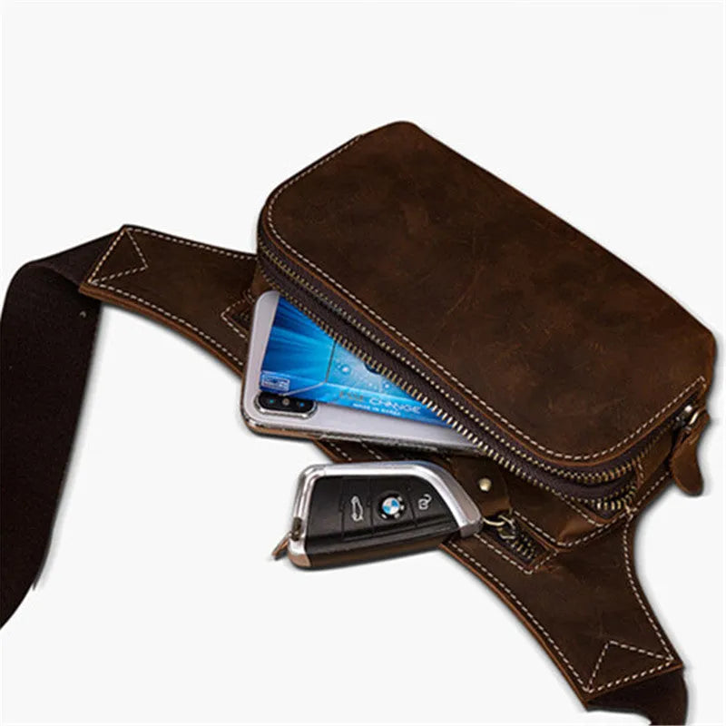 Brown top layer cowhide men's waist bag with pull-cord closure, shown open to reveal internal laptop sleeve and phone pocket.