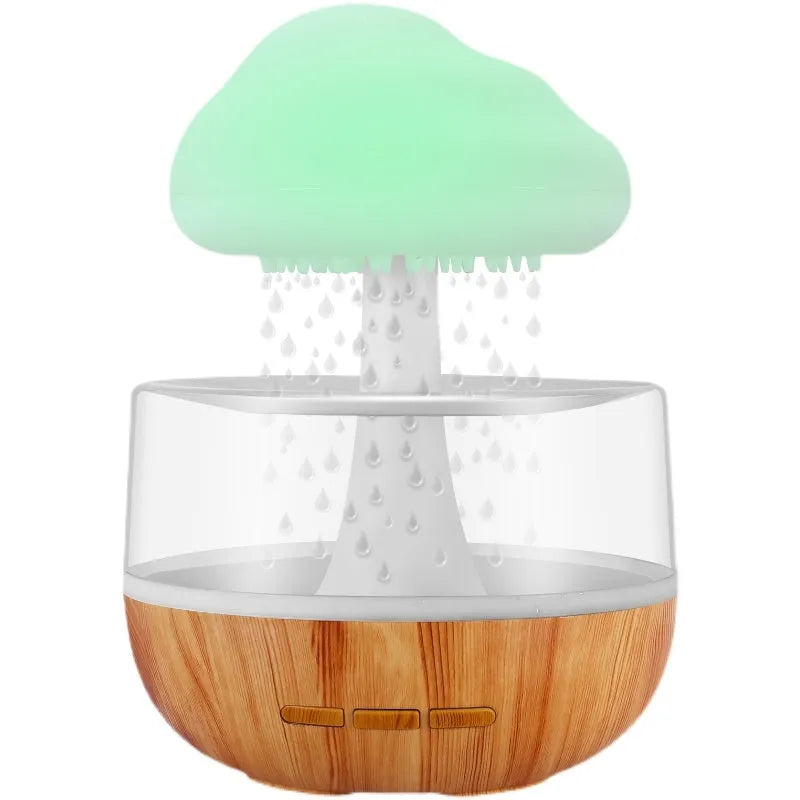 White cloud-shaped humidifier and essential oil diffuser with coloured mood light on.