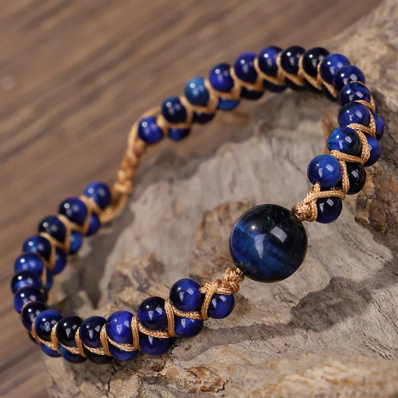 Close-up of a handmade geometric bracelet woven with blue Tigereye stone beads, showing its textured pull-on design.