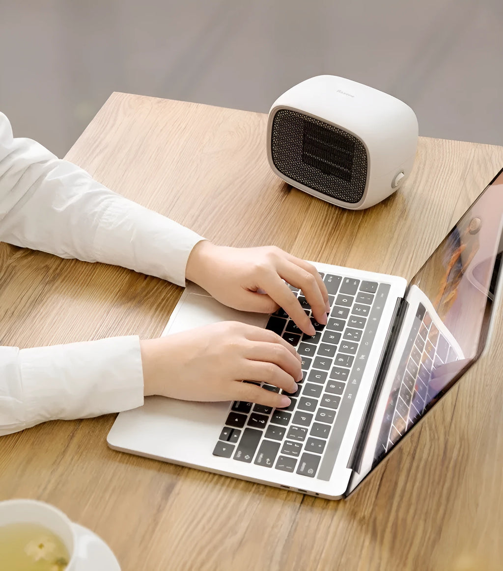 Compact green mini ceramic heater on a desktop showing its small size and EU plug.