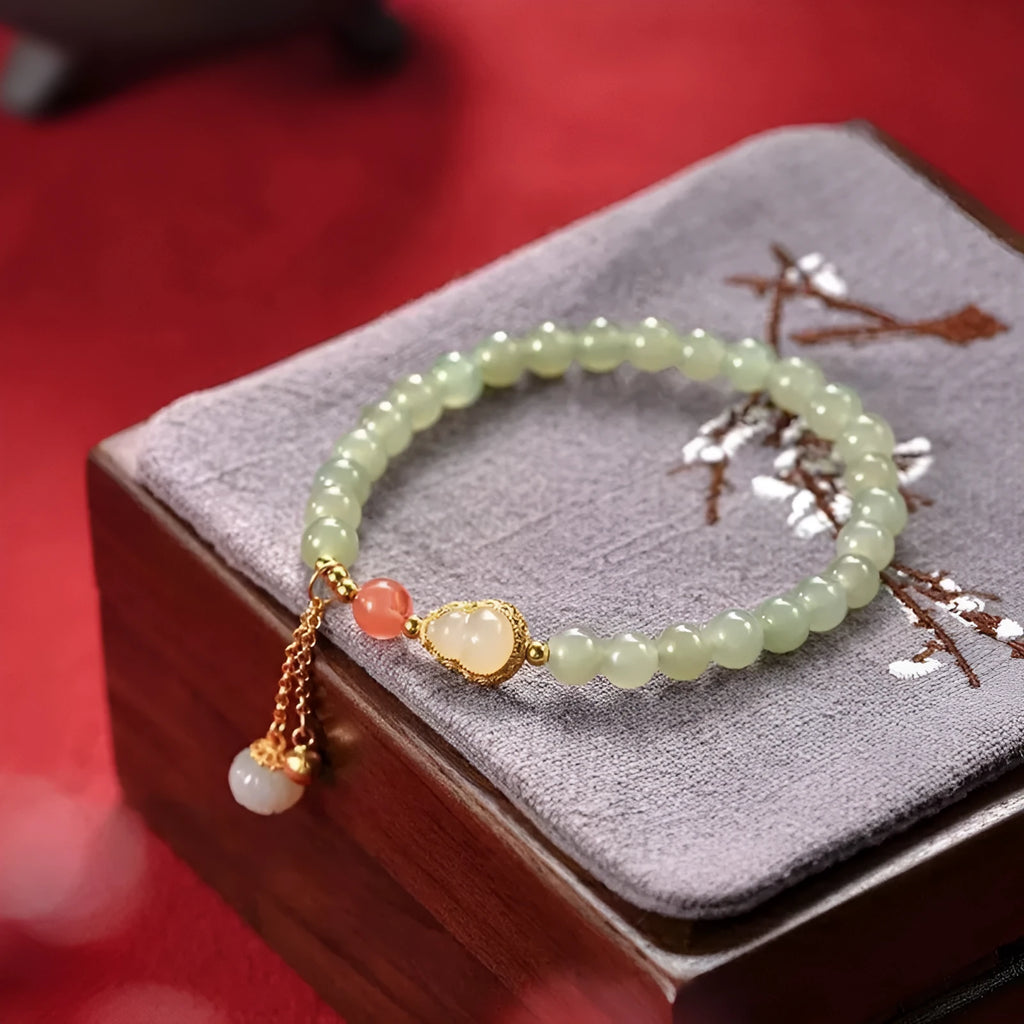 Qingshui jade bracelet with gold-plated details and a fu character on 6mm beads.