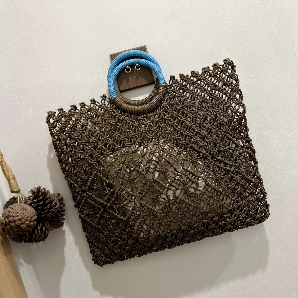 Dark brown handmade straw tote bag with square vertical shape and sandwich pocket design