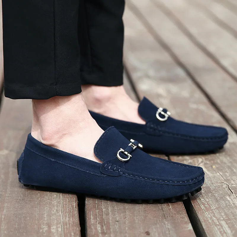 Men's black slip-on leather shoes with square toe and flat rubber sole on a neutral background.