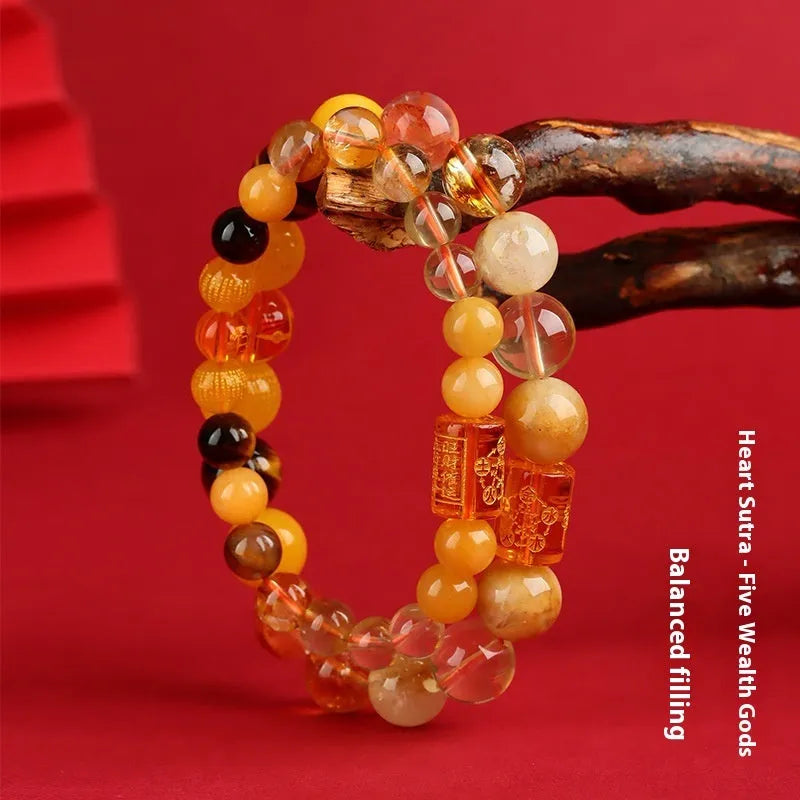 Handmade geometric crystal bracelet in gold, wood, water, fire, or soil colours on a wrist.